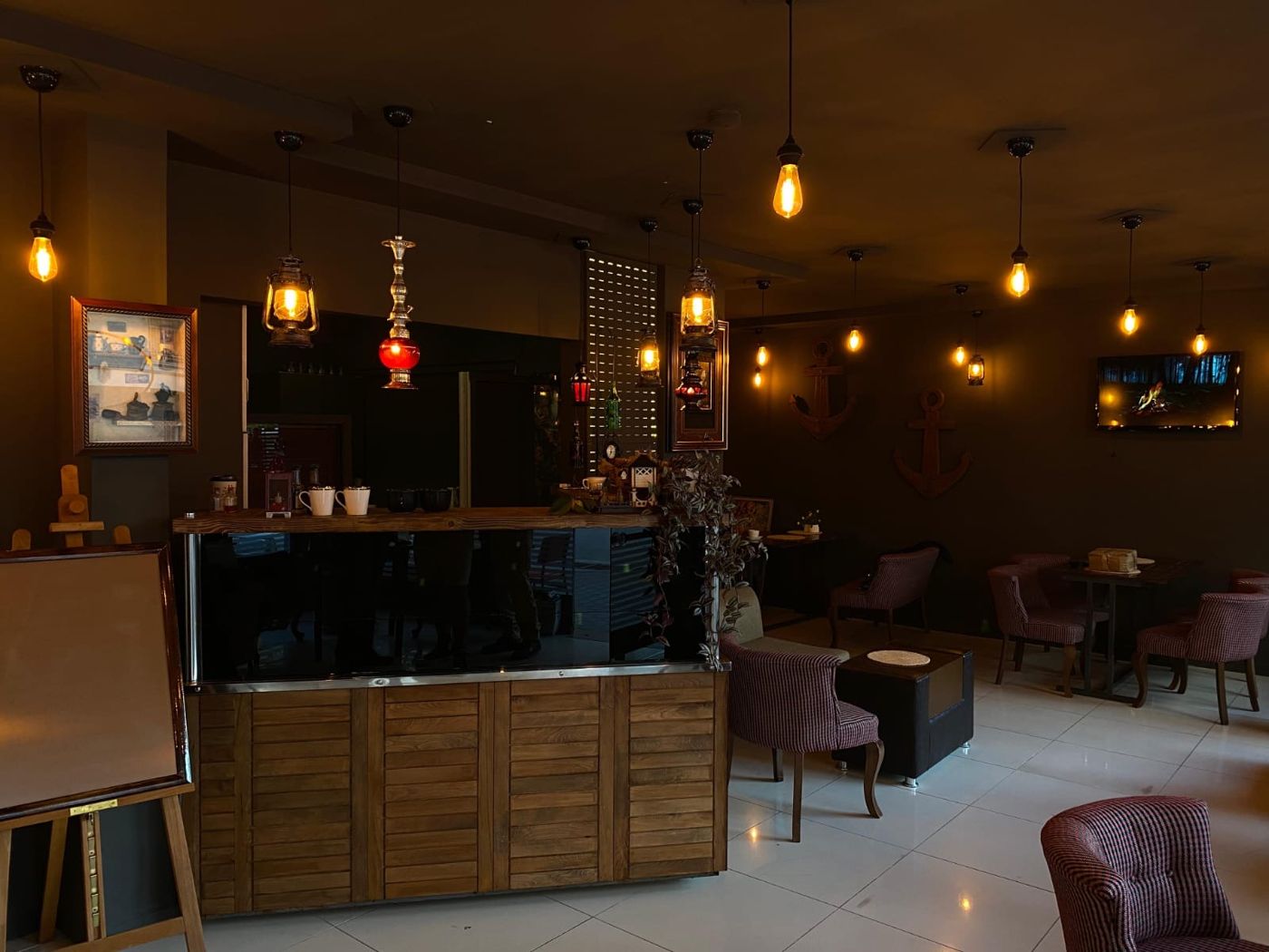 Fenerlerle aydınlatılmış salon ve ahşap bar